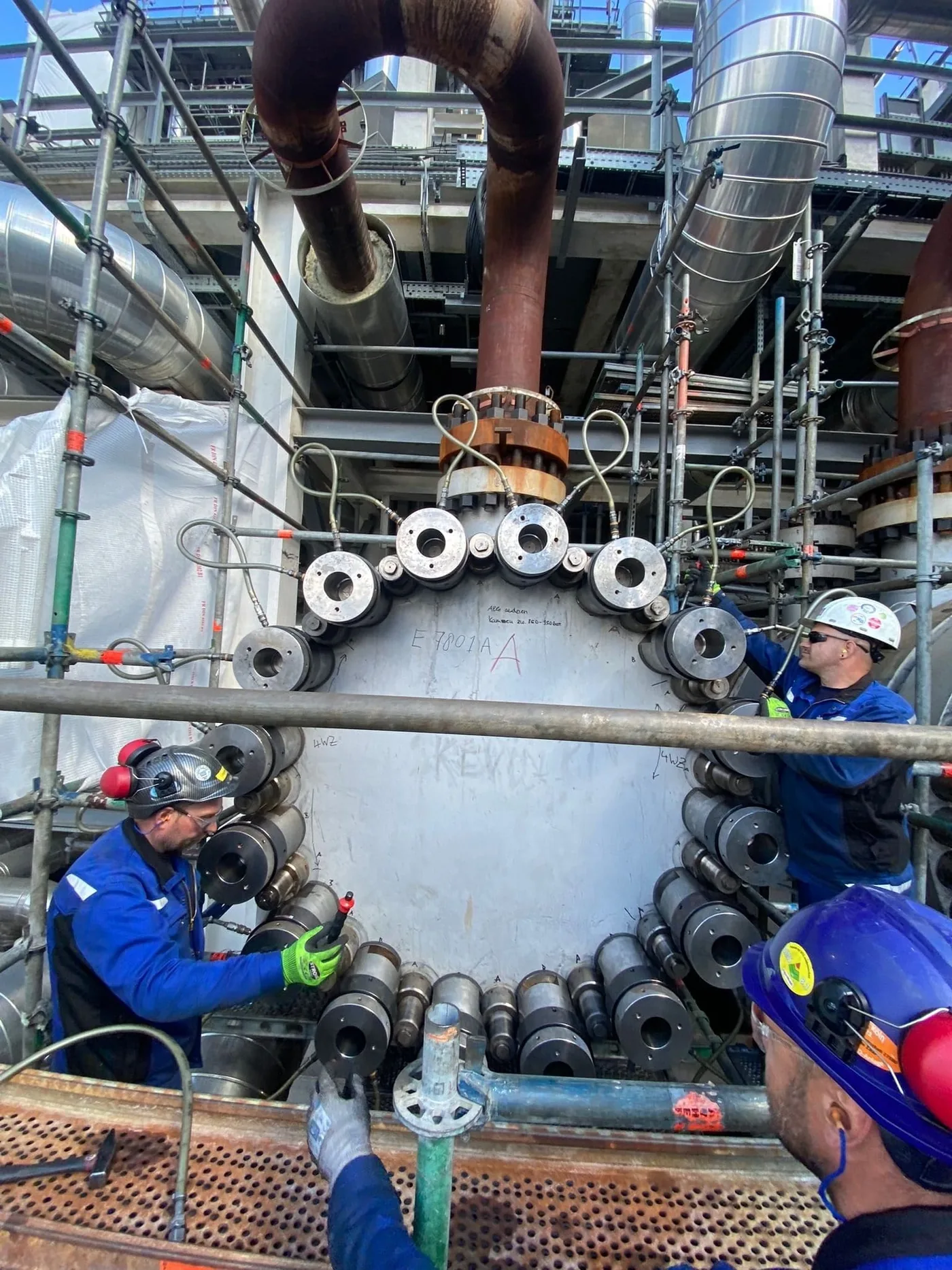 Hydraulic tensioners on a heat-exchanger flange