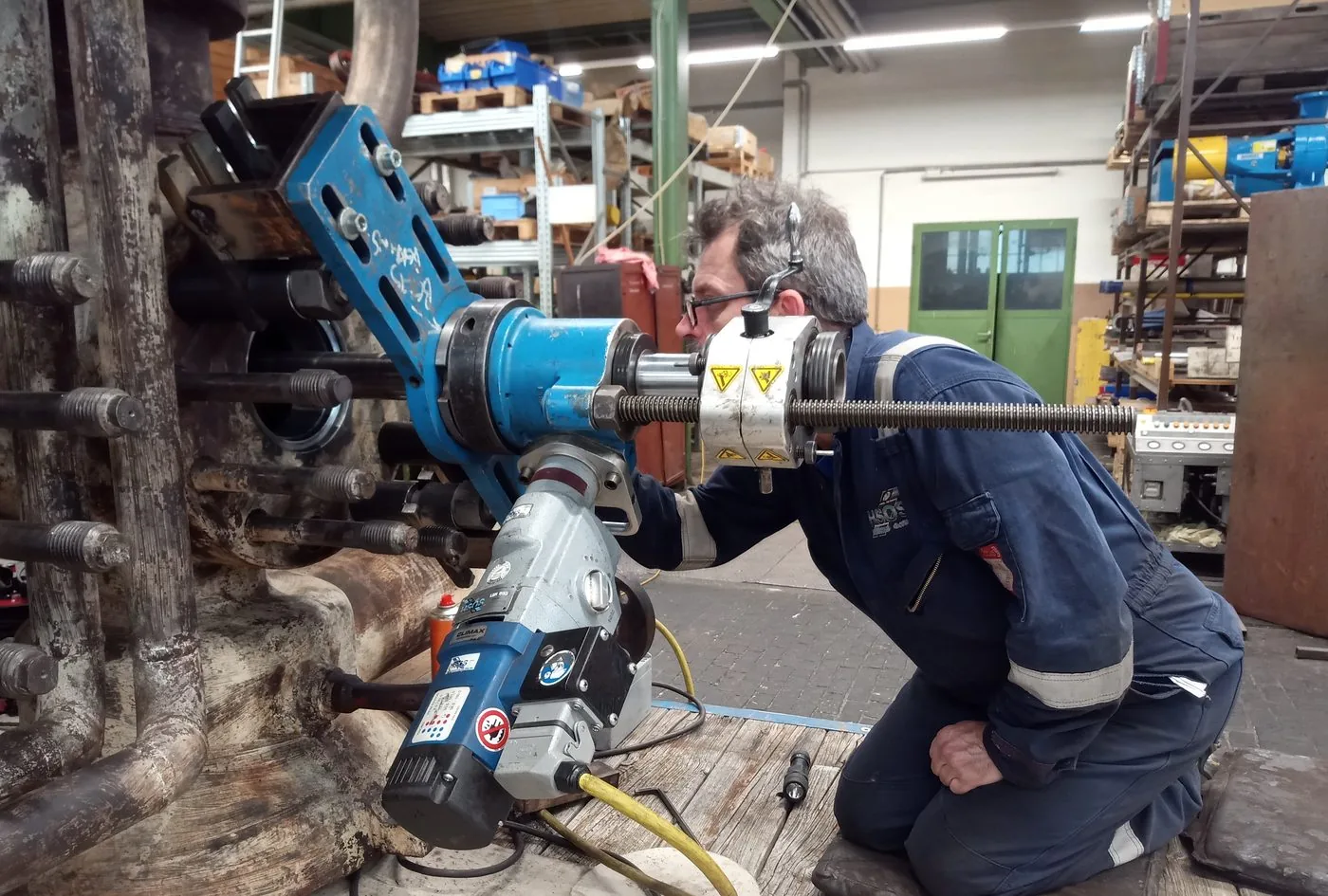 Technician line-boring a component flange in the workshop